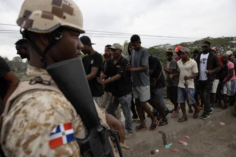 $!Militares dominicanos controlan el flujo de haitianos que esperan cruzar la frontera para abastecerse de productos, principalmente alimentos, este lunes, en el Mercado Binacional en Dajabón (República Dominicana).