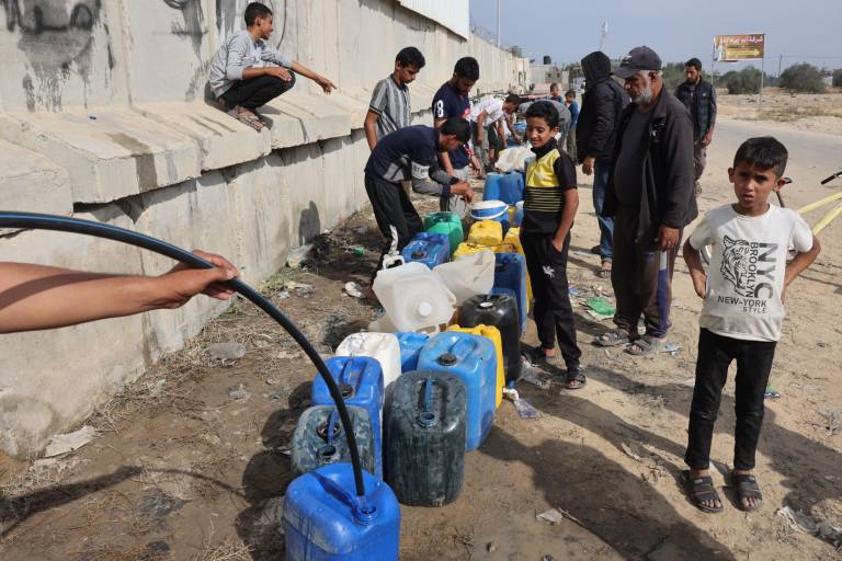 $!Niños palestinos llenan contenedores con agua en Rafah, en el sur de la Franja de Gaza, el 13 de noviembre de 2023, en medio de las batallas en curso entre Israel y el grupo militante palestino Hamás.