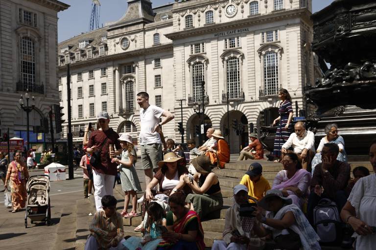 $!Personas se refrescan en Piccadilly Circus, Londres, el 24 de mayo de 2026.