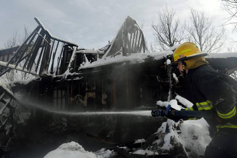 $!Un bombero del Distrito de Protección contra Incendios de Timberline rocía agua sobre una casa cubierta de nieve que aún arde por el incendio Marshall en el vecindario Rock Creek de la ciudad de Superior en el condado de Boulder, Colorado, el 1 de enero de 2022.