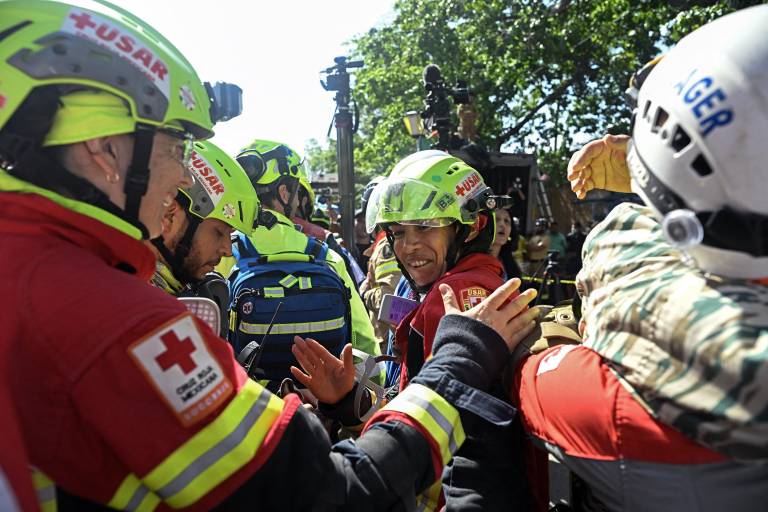 $!Equipos de rescate mexicanos celebran tras subir a una ambulancia a Hernán Gil, quien había sido rescatado, en Catia La Mar, estado de La Guaira, Venezuela, el 2 de julio de 2026.