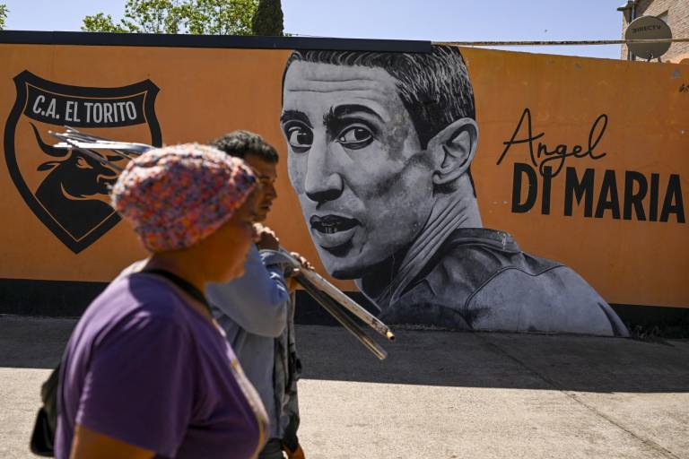 $!La gente pasa junto a un mural de la estrella del fútbol argentino Ángel Di María en el campo del club de fútbol El Torito, donde Di María comenzó en Rosario, Argentina, el 21 de octubre de 2022.