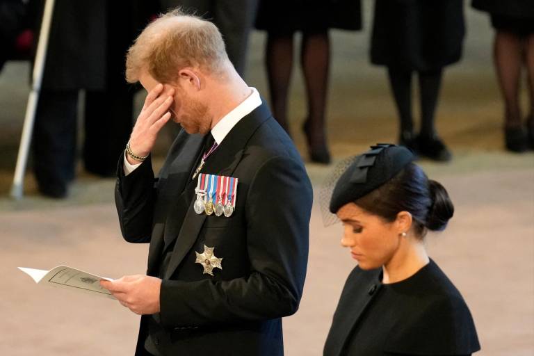 $!El príncipe Harry de Gran Bretaña (izquierda), duque de Sussex, se limpia una lágrima mientras presenta sus respetos con Meghan (derecha), duquesa de Sussex dentro de Westminster Hall, en el Palacio de Westminster, donde reposará el ataúd de la reina Isabel II. (Photo by Christopher Furlong / POOL / AFP)