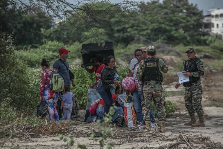 $!Miembros de la policía de Perú controlan el paso de migrantes venezolanos que intentan cruzar la frontera de Perú por la orilla del río Zarumilla, junto a Ecuador el 6 de mayo de 2022.
