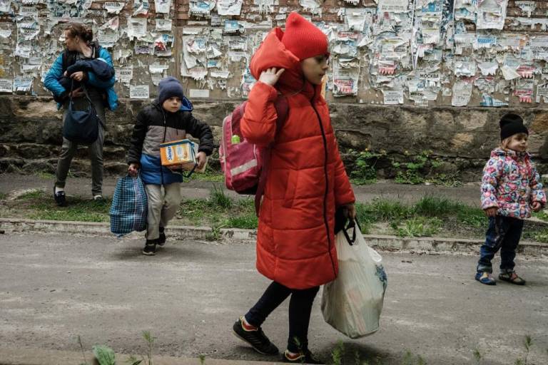 $!Galina (2da a la derecha) camina hacia un autobús a prueba de balas para evacuar con su familia de la ciudad de Lyman, en el este de Ucrania, que ha recibido fuertes bombardeos.