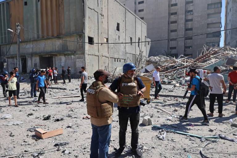 $!Periodistas de Associated Press están en estado de shock junto a los escombros de la Torre Jala, que albergaba oficinas de prensa internacionales, luego de un ataque aéreo israelí en la Franja de Gaza el 15 de mayo de 2021.