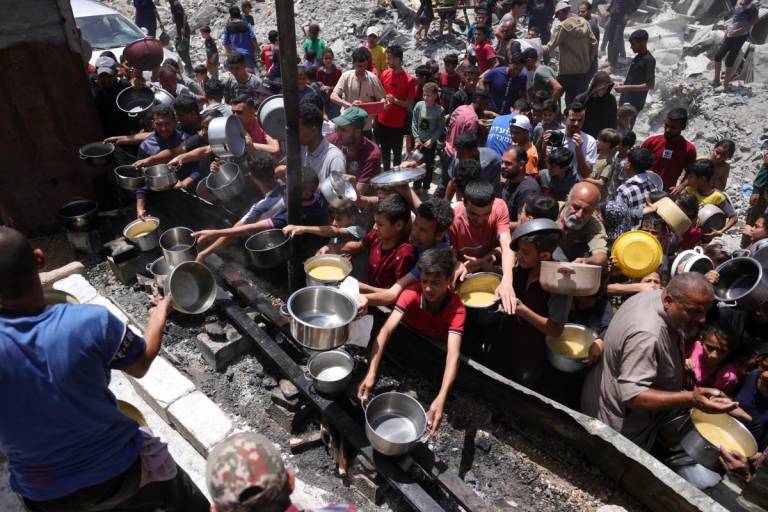 $!Palestinos desplazados se reúnen para recibir porciones de comida.