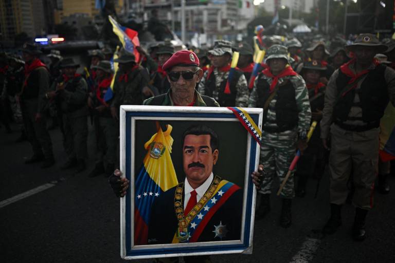 $!Un miembro de la milicia bolivariana sostiene una fotografía del presidente venezolano Nicolás Maduro durante un despliegue militar en apoyo a él en la Avenida Bolívar en Caracas el 23 de septiembre de 2025.
