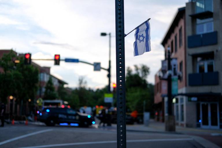 $!Una bandera israelí está fijada a una señal de calle mientras la Policía espera cerca de Pearl Street en la escena de un ataque a los manifestantes.