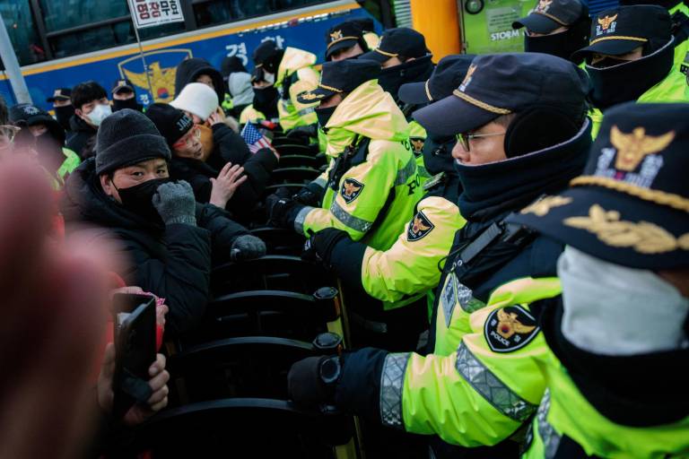 $!Agentes de policía se encuentran en la barricada con partidarios del presidente surcoreano acusado, Yoon Suk Yeol, mientras las autoridades intentan detenerlo.