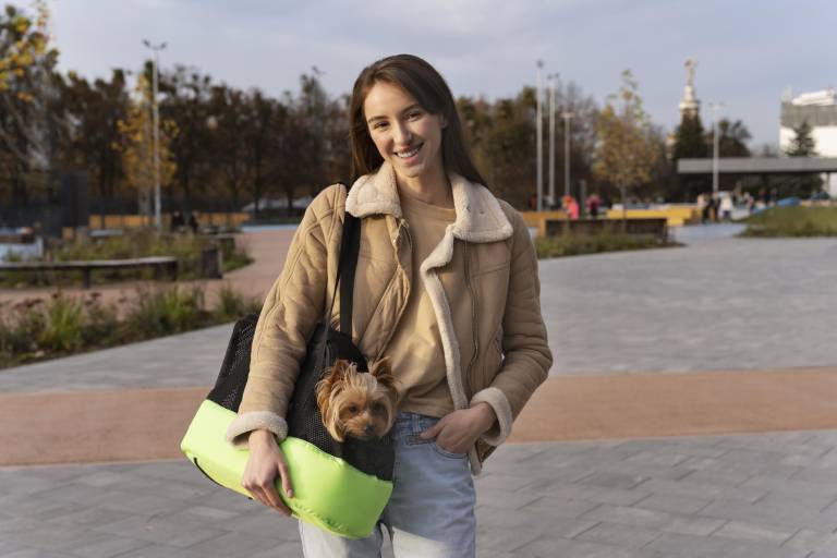 $!Una chica junto a su perro en un transportín.
