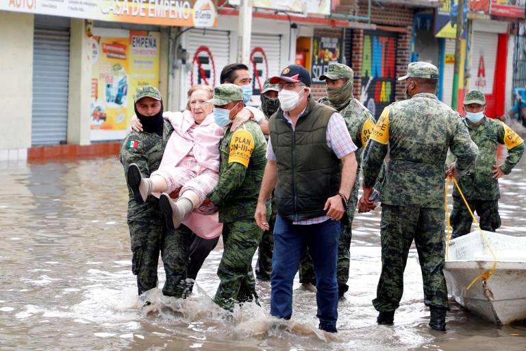 $!Elementos del cuerpo de bomberos y del Ejército Mexicano ayudan a pacientes de un hopsital del Instituto Mexicano del Seguro Social (IMSS) a trasladarse tras verse afectados por una intensa lluvia, hoy en la ciudad de Tula, estado de Hidalgo (México).
