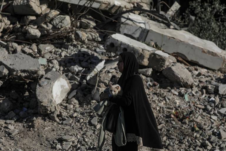 $!Una mujer palestina lleva a su gato después de un ataque aéreo israelí durante una operación militar israelí en la ciudad de Gaza, Franja de Gaza, el 30 de septiembre de 2025.