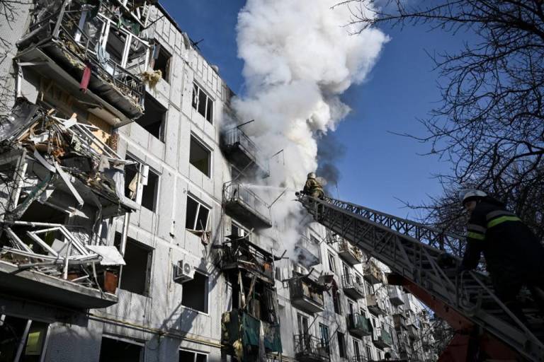 $!Los bomberos trabajan en un incendio en un edificio después de los bombardeos en la ciudad de Chuguiv, en el este de Ucrania, mientras las fuerzas armadas rusas intentan invadir Ucrania desde varias direcciones, utilizando sistemas de cohetes y helicópteros para atacar.