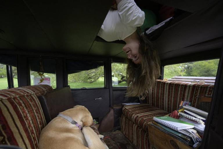 $!Paloma Zapp mira desde una carpa en el techo del auto familiar argentino, un Graham-Paige de 1928, mientras Timón, el perro de la familia, descansa cerca de Gaualeguaychú, provincia de Entre Ríos, Argentina.
