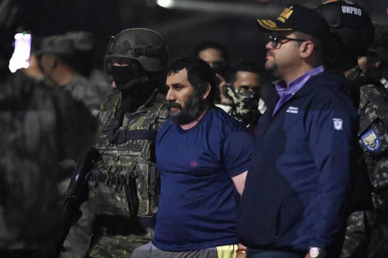 $!El narcotraficante Adolfo Macías, alias Fito, es custodiado por el ministro del Interior de Ecuador, John Reimberg (der.) y personal militar a su llegada a la base aérea de Guayaquil.