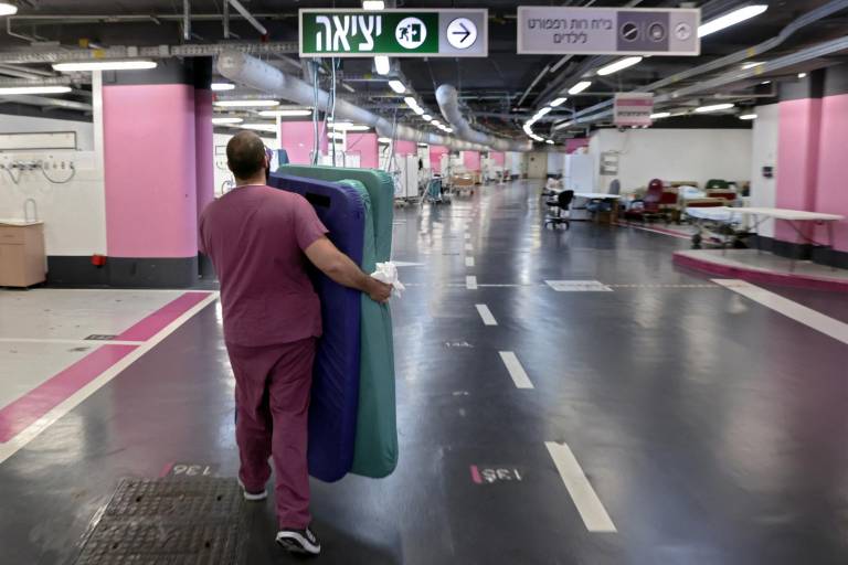 $!Un hombre carga colchones en un hospital subterráneo de emergencia improvisado en el estacionamiento del Rambam Health Care Campus (RHCC) en Haifa, en el norte de Israel, el 12 de octubre de 2023.