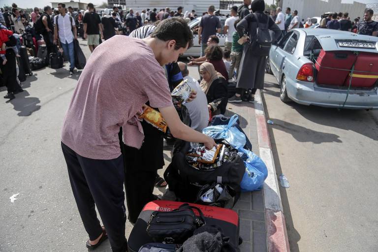 $!Ciudadanos de Palestina esperan para poder pasar por la frontera con Egipto.