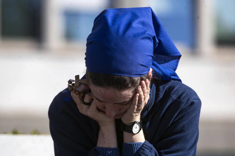 $!Una monja reza delante de la estatua de Juan Pablo II en la entrada del Hospital Gemelli, donde el Papa Francisco continúa hospitalizado.