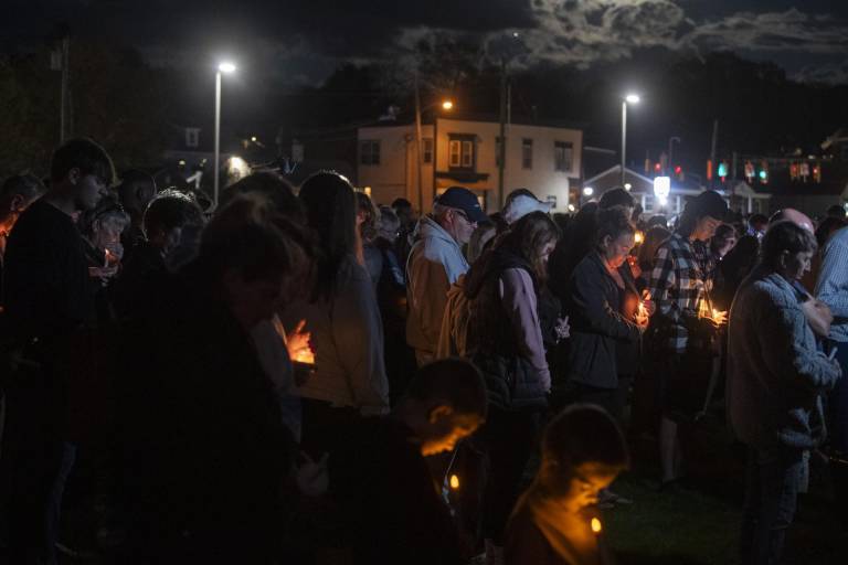 $!La gente se reúne durante una vigilia con velas por las víctimas del tiroteo de Lewiston en la orilla del río Worumbo en Lisboa, Maine, EE. UU., 28 de octubre de 2023.