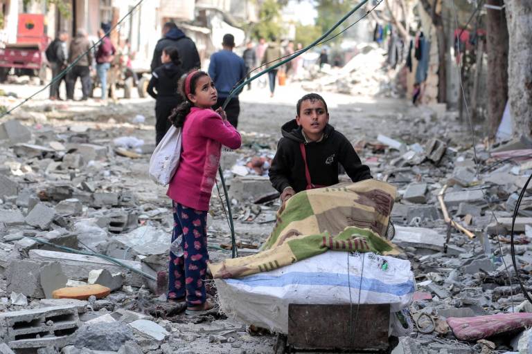 $!Niños palestinos rescatan algunos artículos encontrados en medio de la destrucción causada por el bombardeo israelí en Bureij.