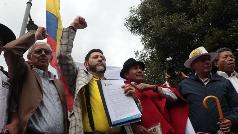 Fotografía que muestra al abogado Washington Andrade (2-I) y al dirigente indígena Leonidas Iza (3-I) frente a la sede del Consejo Nacional Electoral (CNE).