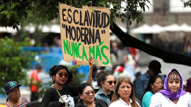 Una mujer sostiene un cartel este sábado, afuera del Palacio de Gobierno en Quito (Ecuador).