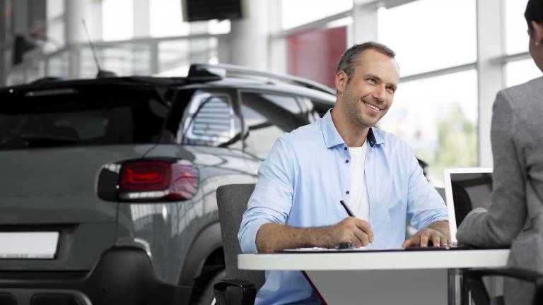 Cliente firmando un contrato vehicular.