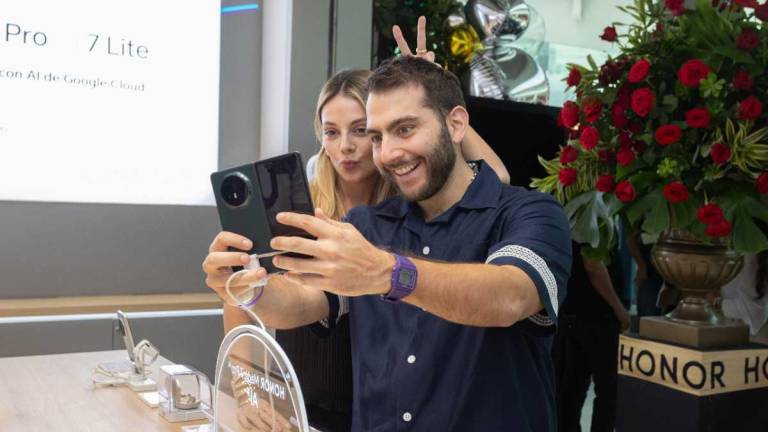 La creadora de contenido Natalia Regge y el cantante John Taleb revisando un smartphone de Honor, en la nueva tienda de experiencia de la marca tecnológica ubicada en el Mall del Sol, Guayaquil.