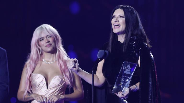 La cantante italiana Laura Pausini sostiene su Grammy Persona del Año junto a la colombiana Karol G (i) en la gala anual de los Latin Grammy.