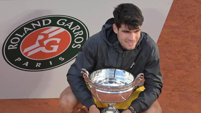 Carlos Alcaraz posa con el trofeo frente al logo de la competición.