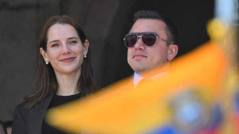 El presidente reelecto de Ecuador, Daniel Noboa (der.), y su esposa, Lavinia Valbonesi, hacen un gesto desde un balcón del Palacio Presidencial de Carondelet.
