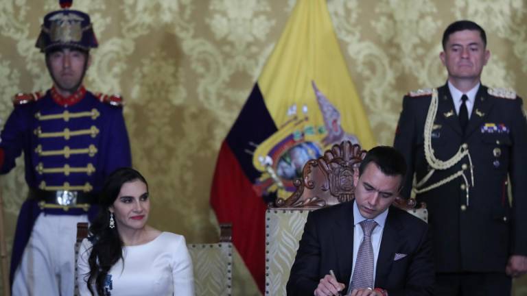 El presidente de Ecuador, Daniel Noboa (d), junto a la vicepresidenta, Verónica Abad (i), firma un documento durante un acto protocolario en el Palacio de Carondelet luego de ser investido en la Asamblea Nacional como jefe de Estado en reemplazo de Guillermo Lasso.