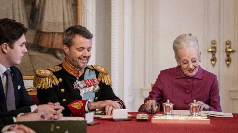 La reina Margarita II de Dinamarca (derecha) firma una declaración de abdicación mientras el príncipe heredero Federico de Dinamarca, quien se convierte en rey Federico X de Dinamarca (centro), y el príncipe Cristián de Dinamarca reaccionan en el Consejo de Estado en el castillo de Christiansborg en Copenhague, Dinamarca, en enero. 14 de enero de 2024.