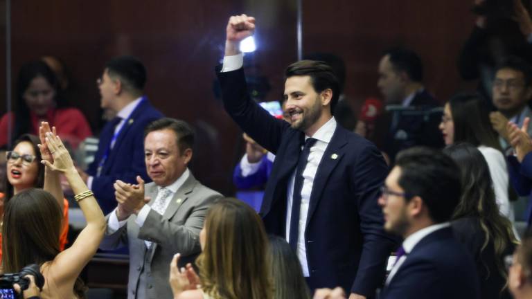 El exministro de Turismo, Niels Olsen (c), celebra tras ser elegido presidente de la Asamblea Nacional de Ecuador por el movimiento oficialista ADN este miércoles, en Quito.