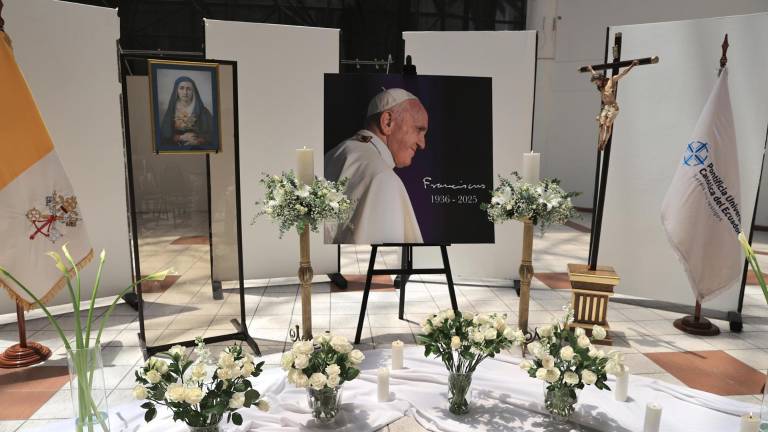 Fotografía que muestra una fotografía del papa Francisco, decorada con flores y velas en memoria del pontífice, este martes en una capilla ardiente ubicada en la Pontificia Universidad Católica (PUCE), en Quito.