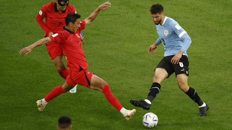 Rodrigo Bentancur de Uruguay disputa un balón con Jung Woo-young de Corea del Sur.