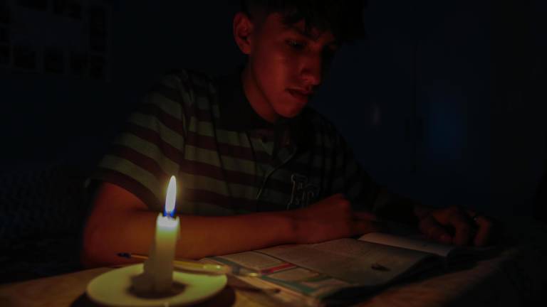 Un estudiante lee un texto a la luz de una vela este miércoles en Quito.