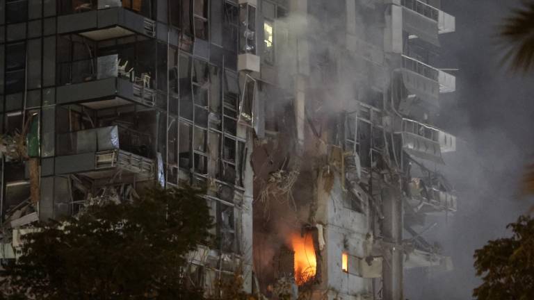 El fuego y el humo se elevan desde un edificio, presuntamente alcanzado por un misil disparado desde Irán, en el centro de Tel Aviv el 13 de junio de 2025.