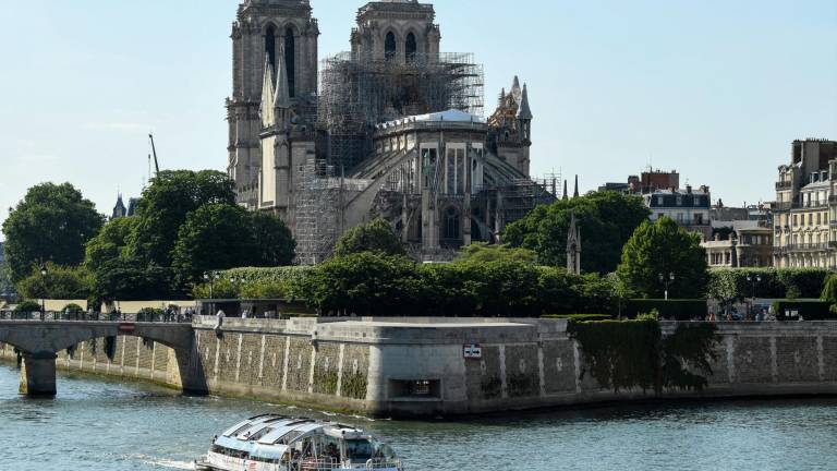 Un barco navega a lo largo del río Sena pasando por la plaza Jean XXIII y la plaza de l'Ile de France al pie de la catedral de Notre-Dame de París, en reparación después de que fuera gravemente dañada por un gran incendio el 15 de abril, en París, la capital francesa, el 31 de mayo de 2019.
