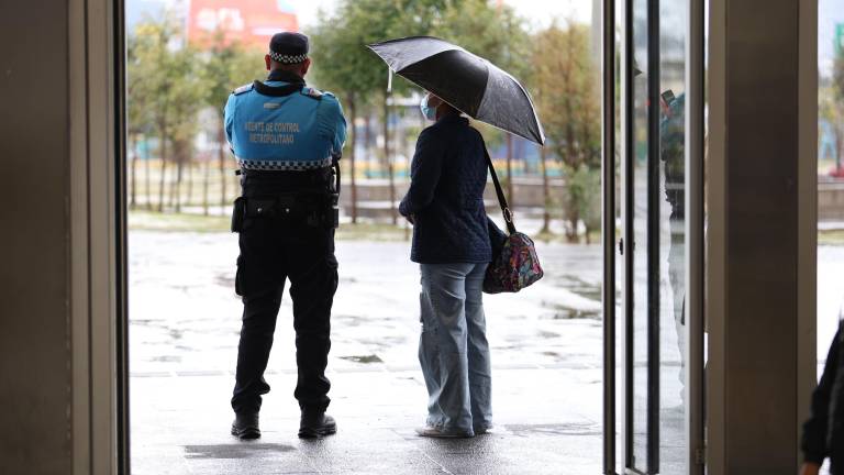 Dos personas viendo la lluvia en la ciudad de Quito.