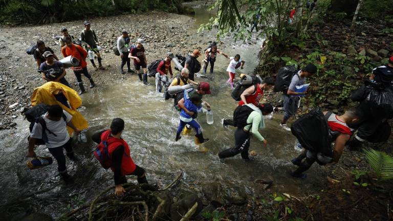 Personas cruzan un río en la selva de Darién