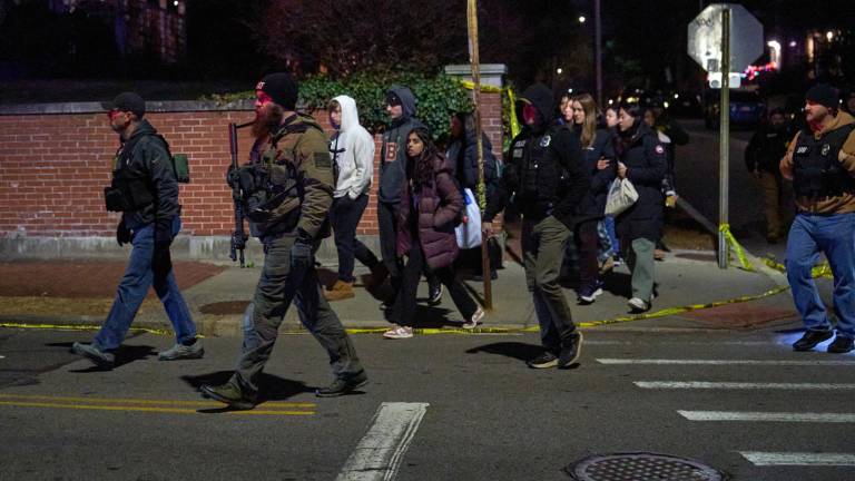 Agentes del orden escoltan a estudiantes cerca del edificio de ingeniería Barus &amp; Holley en el campus de la Universidad de Brown en Providence.