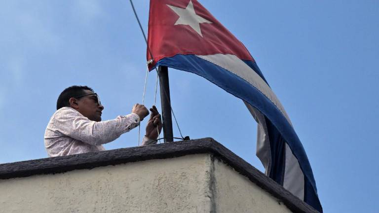 Un empleado de la embajada de Cuba en Quito baja la bandera nacional cubana, este viernes 6 de marzo de 2026.