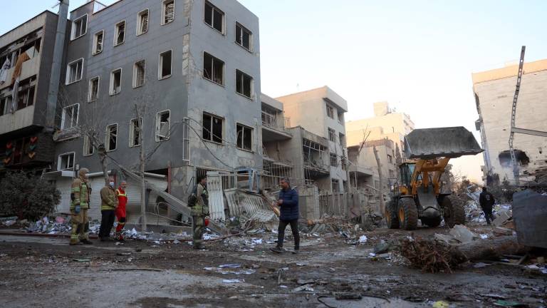 Bomberos y funcionarios trabajan en una zona residencial cerca de la plaza Niloufar tras un ataque aéreo en Teherán, Irán.