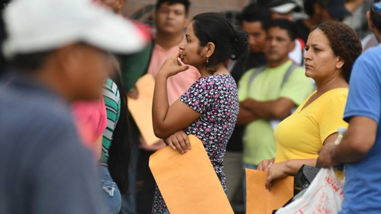 Varias personas hacen fila en los exteriores de una empresa privada en Manta ante una convocatoria para nuevas plazas de empleo.