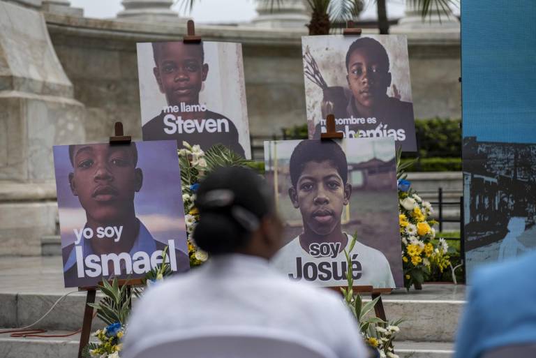 $!Un familiar de los cuatro niños víctimas de desaparición forzada observa fotografías durante un acto de perdón este jueves, en Guayaquil.