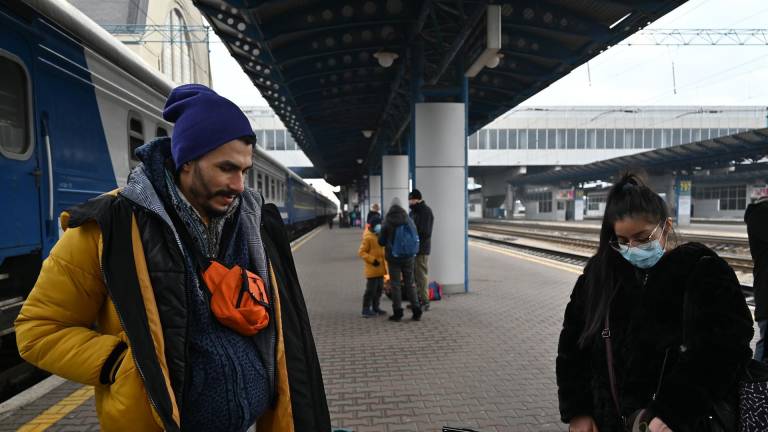 El estudiante ecuatoriano Gabriel, junto a una compatriota en el andén de la estación central de Kiev este viernes. Esperan tren con destino a Lviv, la ciudad más importante del oeste ucraniano.