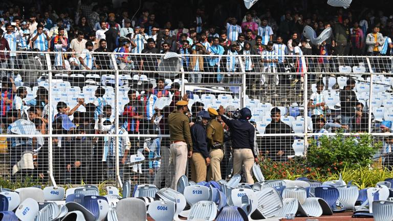 Los aficionados lanzan sillas mientras el delantero argentino número 10 del Inter de Miami, Lionel Messi, sale del Estadio Salt Lake en Calcuta.