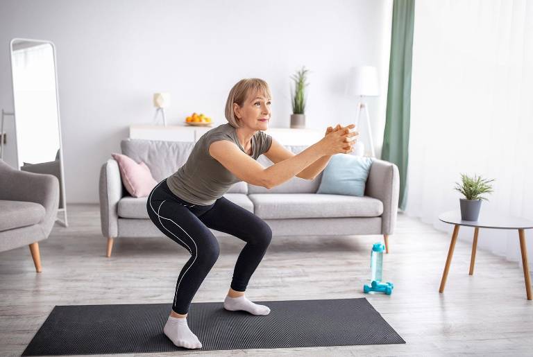 $!Mujer adulta haciendo sentadillas en casa, en un espacio libre.